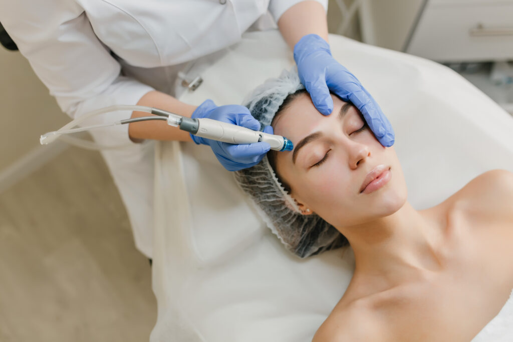 View from above rejuvenation of beautiful woman enjoying cosmetology procedures in beauty salon. Dermatology, hands in blue glows, healthcare, therapy, botox. Lasers treatment for acne